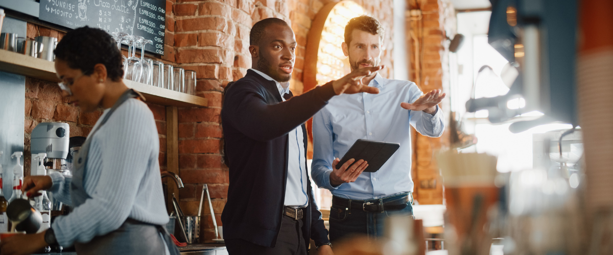 A Male Small Business Owner Of A Coffee Shop Speaking With An SBA Loan Lender