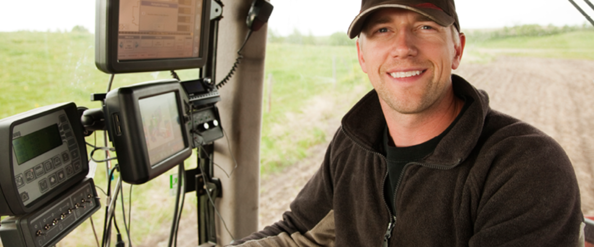 Farmer managing ag equipment in the field, representing loans and agricultural financing options for farmers