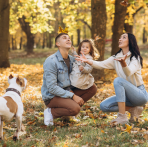 Image of a family in the park playing with leaves