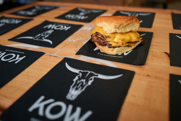 Image of Burger Sitting on a KOW Steaks Napkin