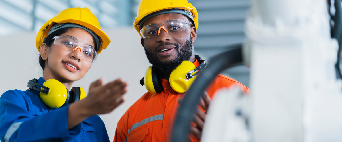 Male and female small business owners using an equipment loan on a robotic welder in the manufacturing industry