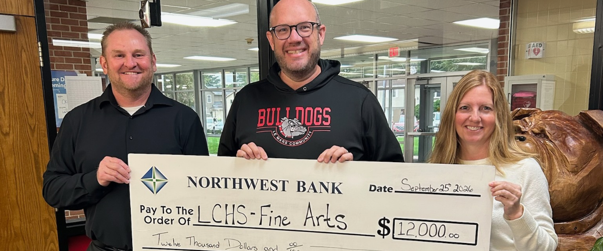 Brad Cave, Bank President, VP and Noelle Kneip, Residential Real Estate, VP presented the donation to Michael Prichard, Instrumental Music/HS Marching Band Teacher