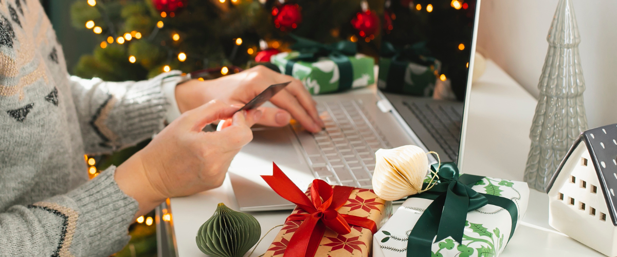 Image Of Person Holding A Credit Card With Presents