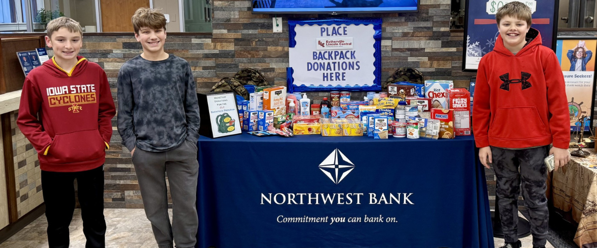 Garret Fehr, Mason Curry and Easton Quastad students from ELC present funds raised as a donation.