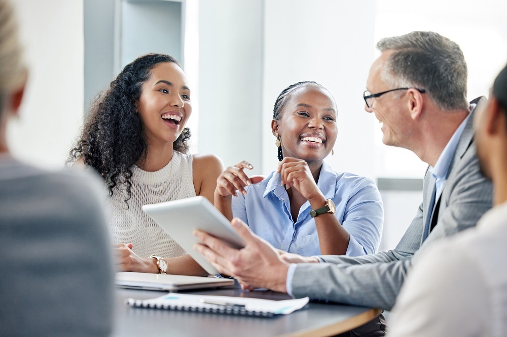 Colleagues sitting around table with tablet