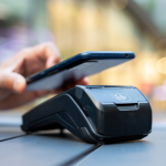 A Person Using Their Digital Wallet To Pay At A Store
