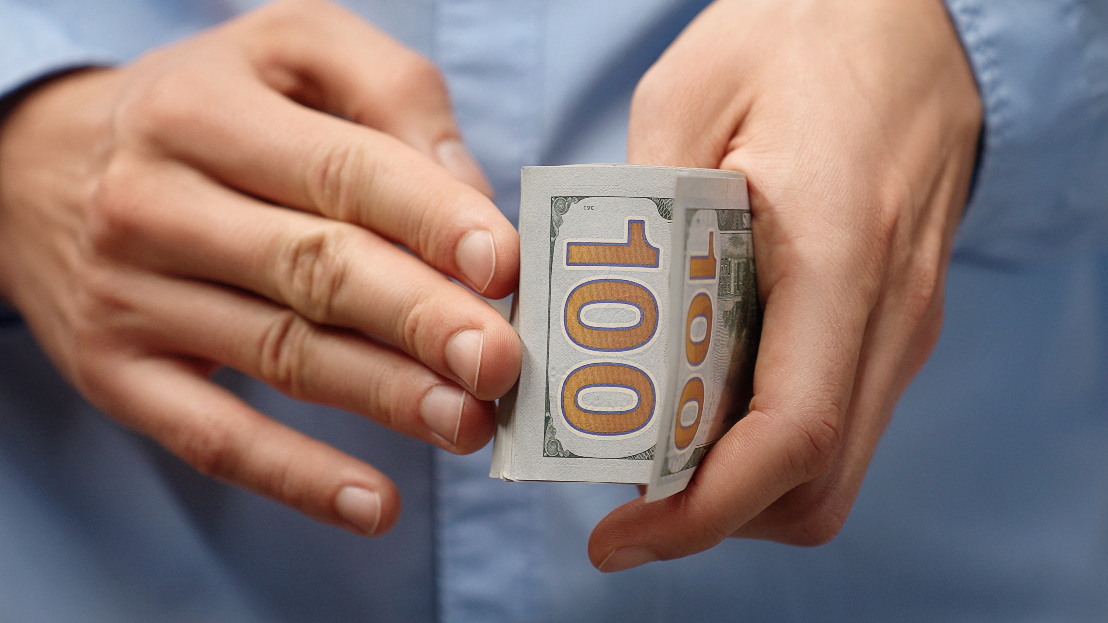 Image Of A Man Holding a $100 Bill