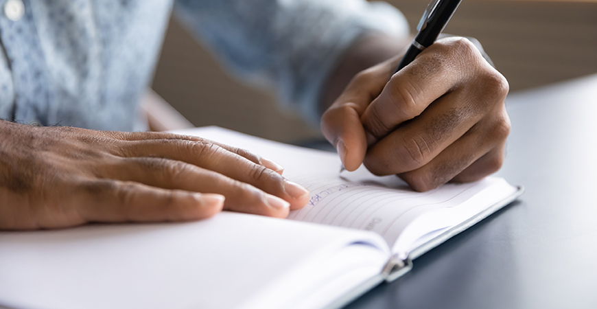 image of person writing in notebook